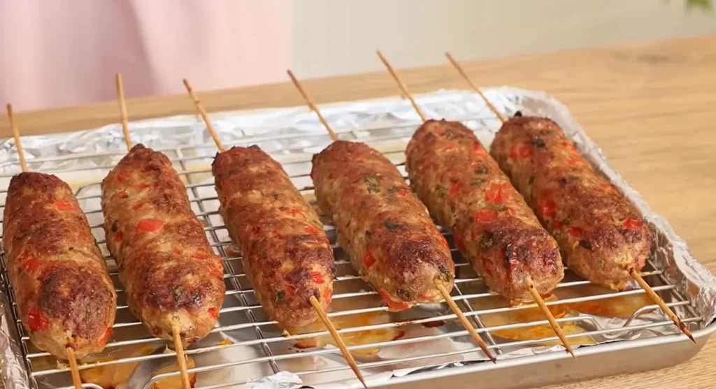 Juicy Turkish-style minced meat kebab baked with herbs and vegetables on wooden skewers