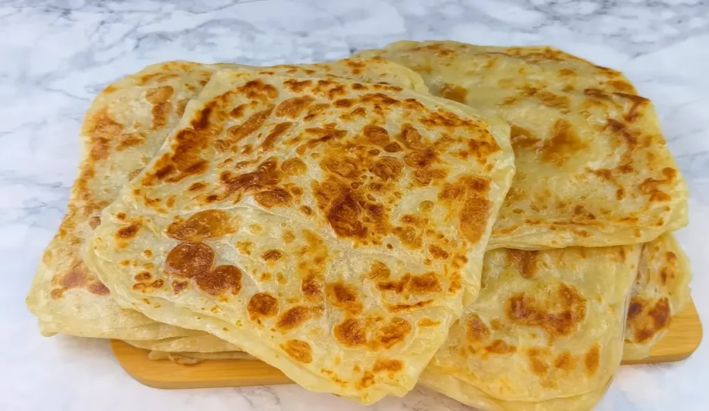 Homemade Turkish katmer cooked in a pan with flaky buttery layers