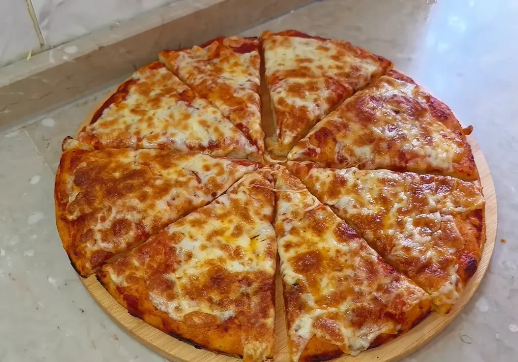 Turkish tray pizza with melted kaşar cheese and homemade tomato garlic sauce