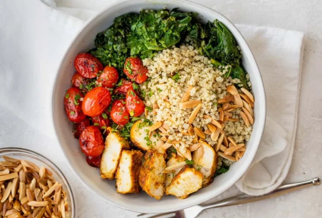Grilled chicken quinoa bowl with fresh vegetables and yogurt dressing