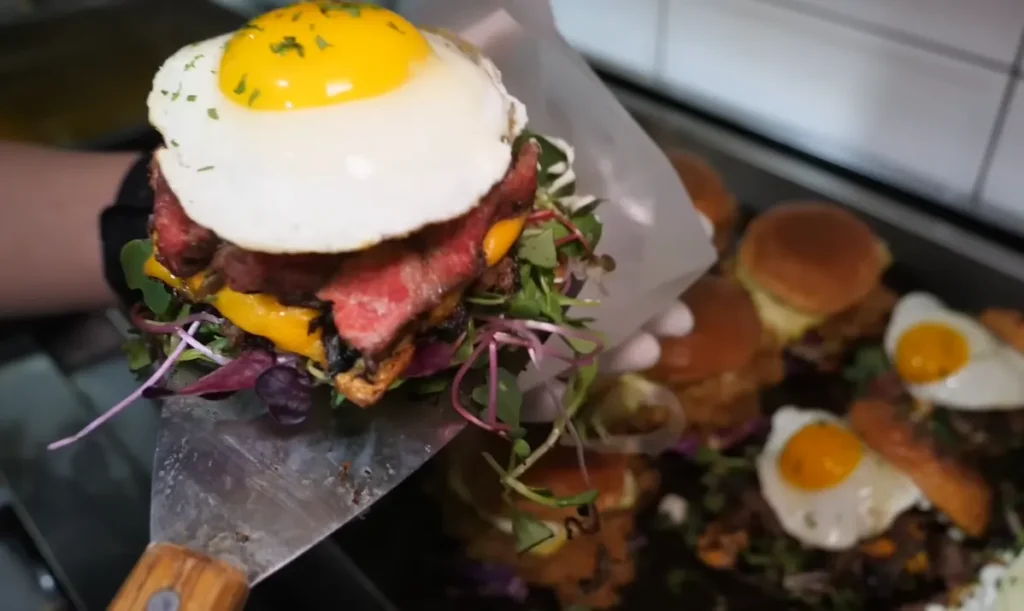 Japanese-style chicken and steak cheeseburger with melted cheese red cabbage pickles and creamy sauce