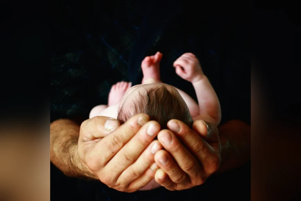 Newborn baby sleeping safely while a parent provides gentle care