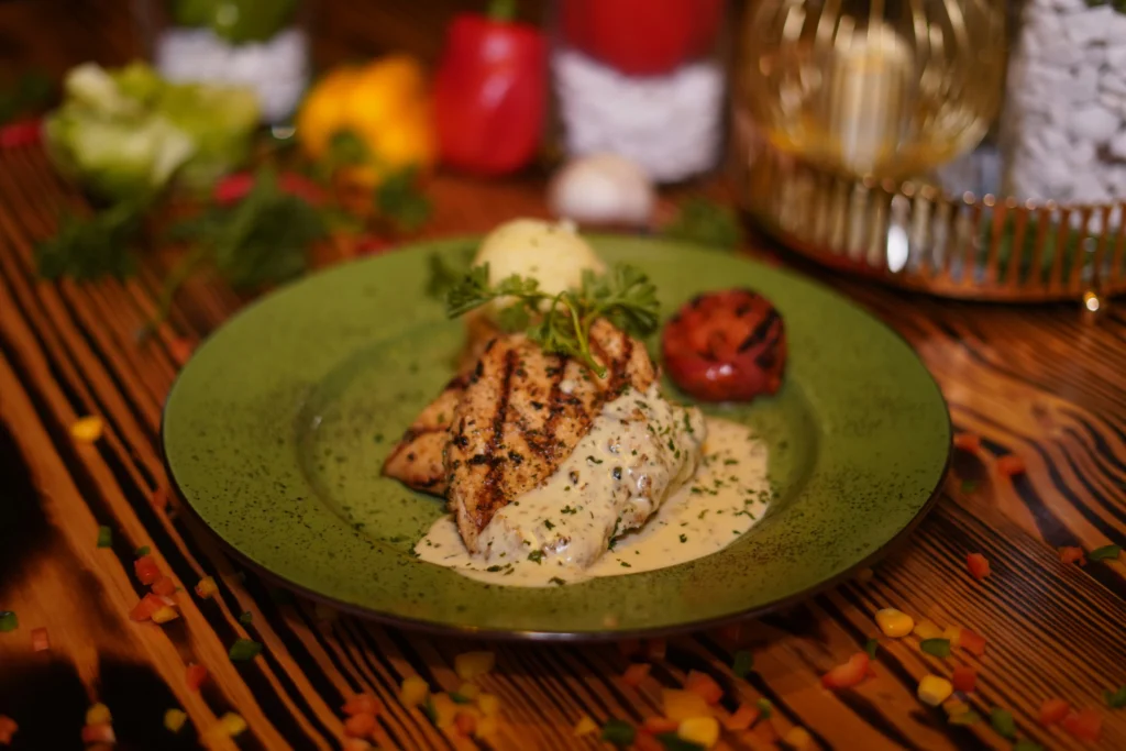 Prawn stuffed chicken steak with grilled vegetables on a serving plate