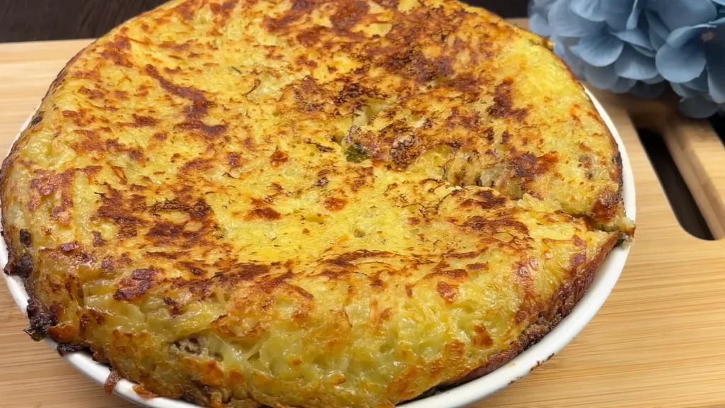 Crispy Potato Casserole With Ground Beef, Mozzarella, and Creamy Garlic Sauce Golden potato casserole with a crispy browned surface served on a white plate.