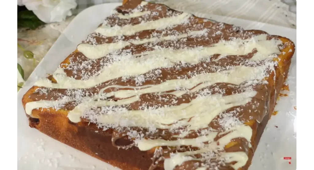 Moist chocolate coconut cake topped with melted chocolate and shredded coconut
