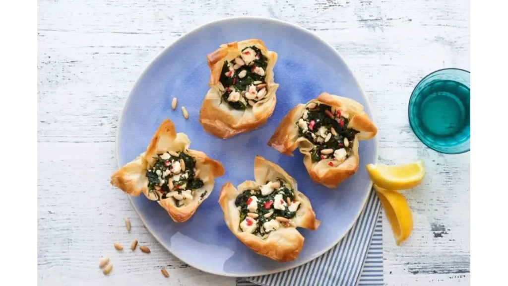 Spinach Baked Pies: Crispy Spinach and Cheese Bites Golden spinach baked pies filled with cottage cheese, garlic, and chopped almonds in crisp pastry shells.